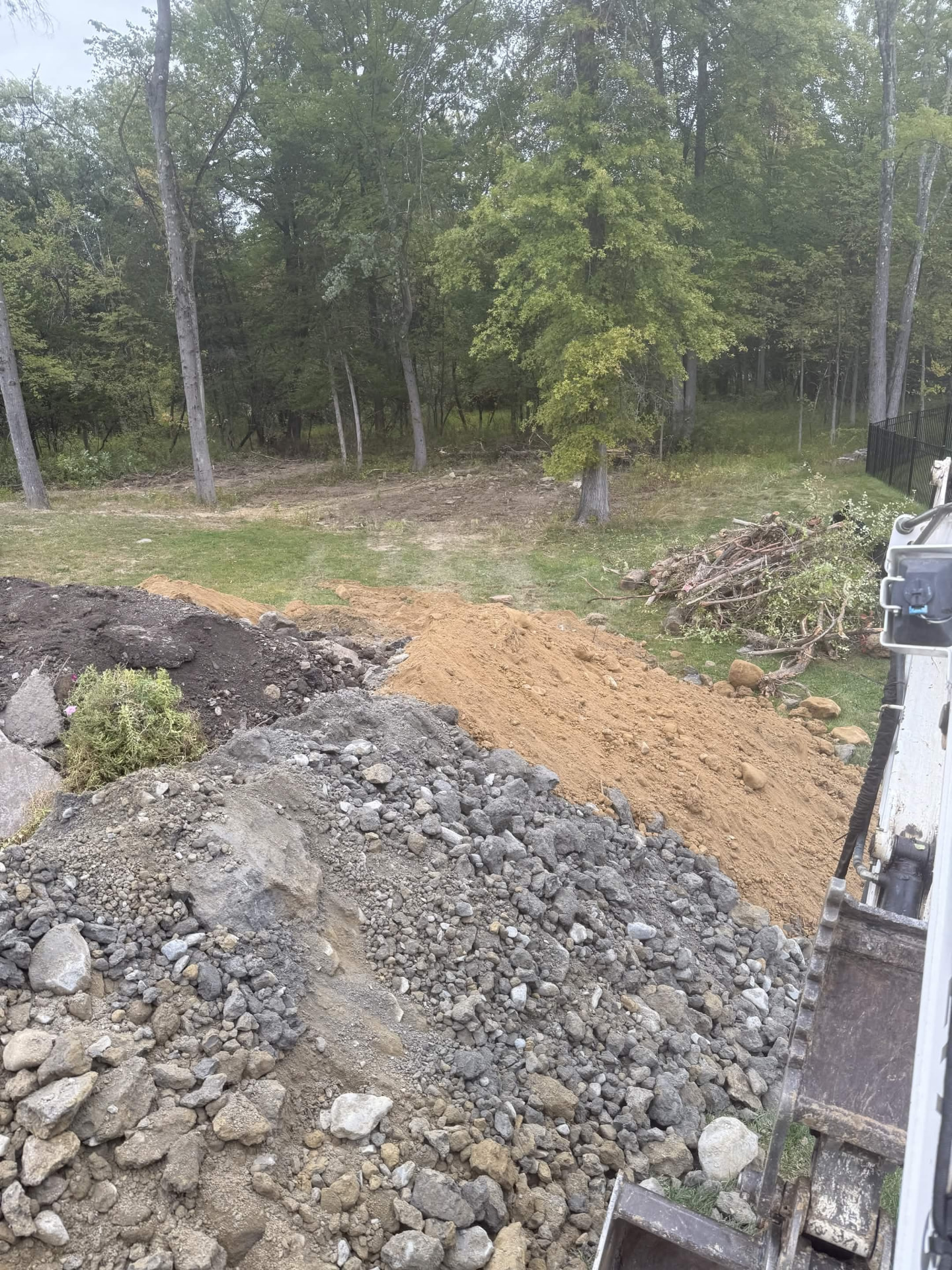 Excavator cutting and hauling soil on a residential lot