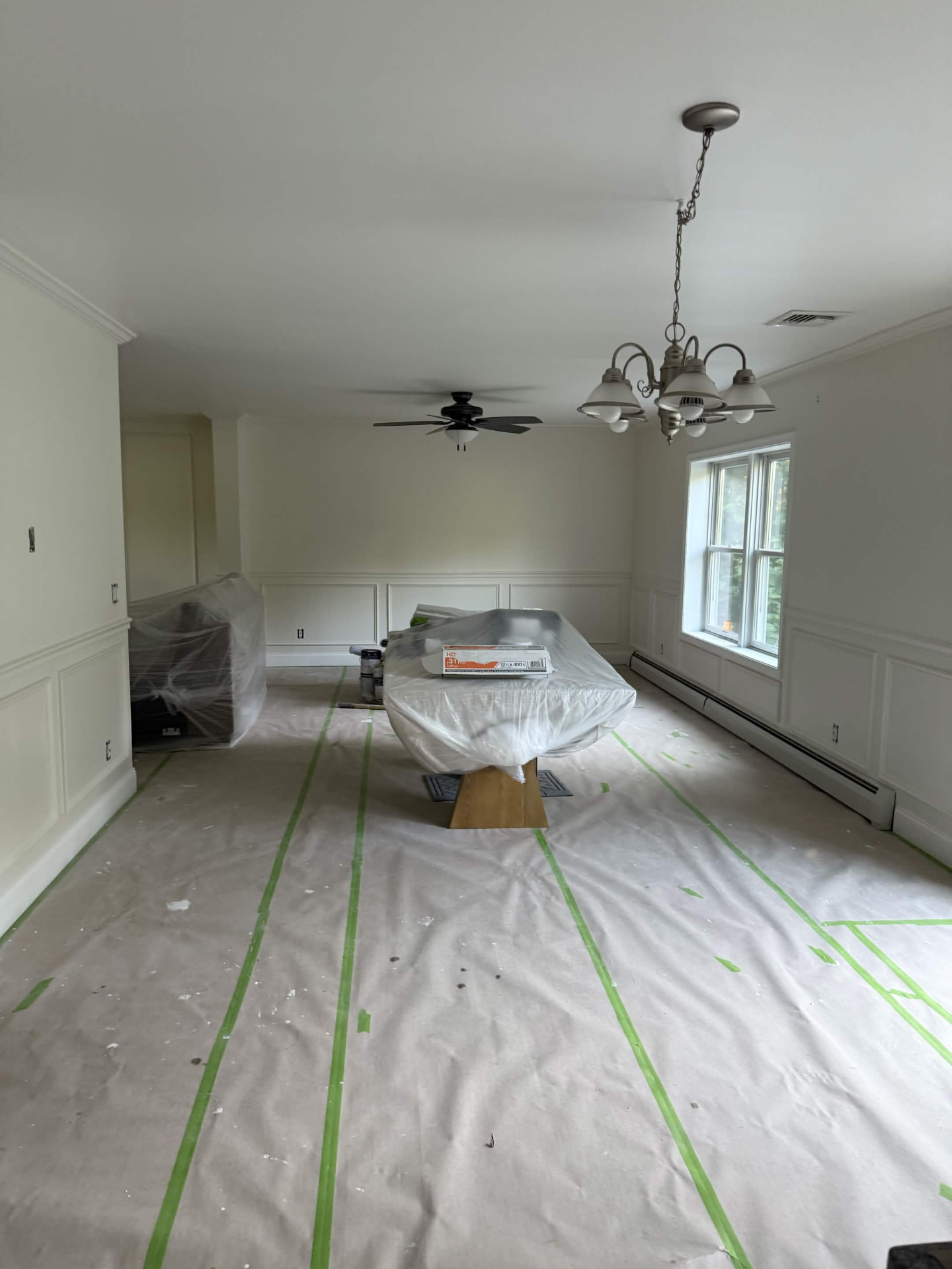 Living room prepped with drop cloths ahead of painting