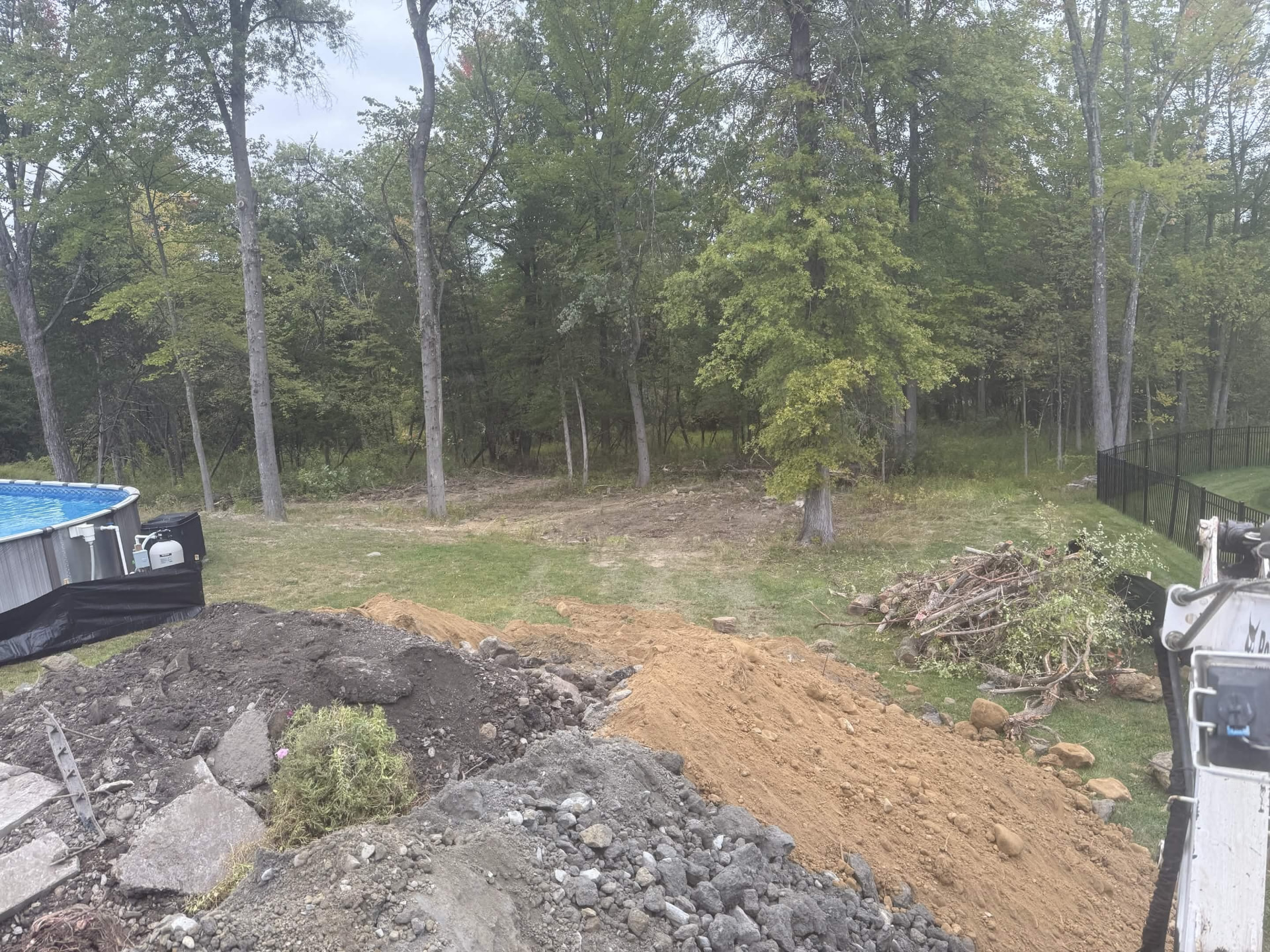 Rough grading in progress on a wooded back lot