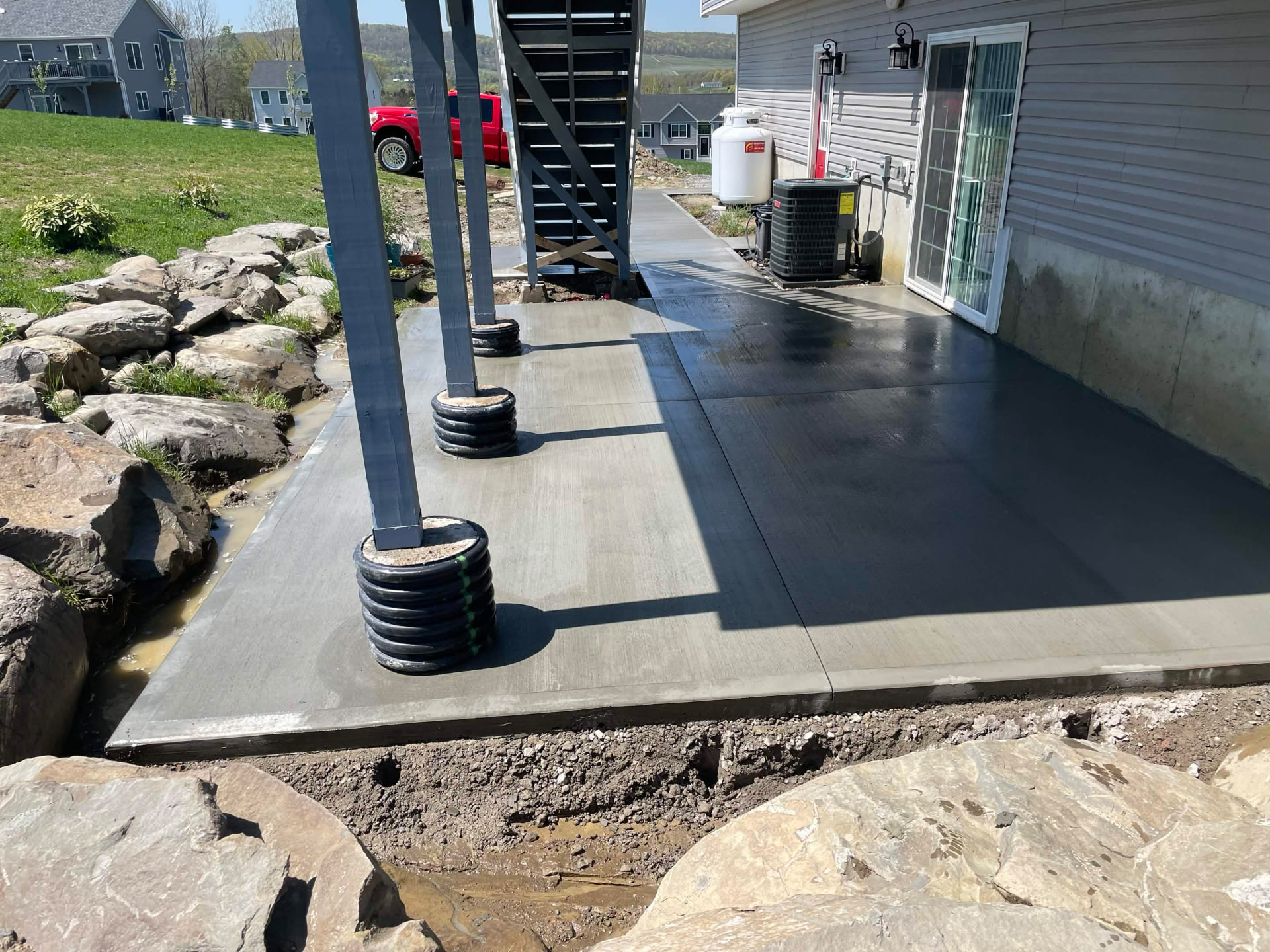 Finished concrete patio bordered by natural stone
